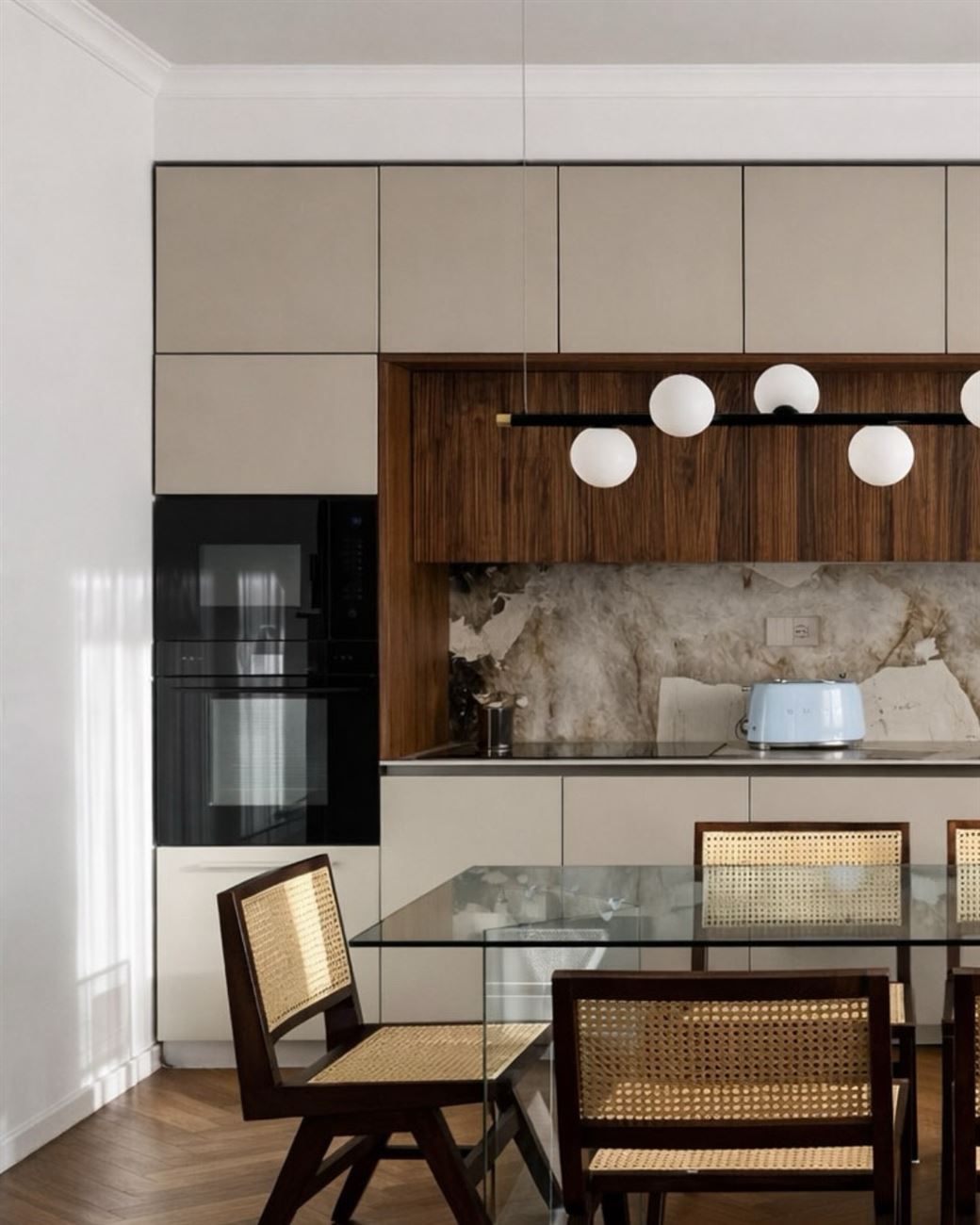 Cucina con boiserie in legno e tavolo in vetro